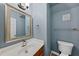 Cozy powder room with a decorative mirror, and a wood vanity with chrome fixtures at 1605 Old London Way, Apex, NC 27523