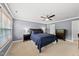 This primary bedroom features plush carpet, a ceiling fan, and a neutral color palette at 1605 Old London Way, Apex, NC 27523