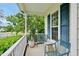 Cozy front porch featuring stylish blue chairs, complementing blue shutters and lush greenery at 1605 Old London Way, Apex, NC 27523