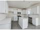 Bright kitchen features white cabinets, subway tile backsplash, stainless appliances, and gray wood-look flooring at 173 Copperleaf Court, Franklinton, NC 27525