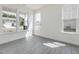 Sun-lit living room featuring modern wood-look floors and a series of large windows at 173 Copperleaf Court, Franklinton, NC 27525