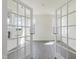 Bright living room with wood-look flooring, large windows, and elegant glass paneled French doors at 173 Copperleaf Court, Franklinton, NC 27525