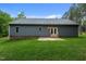 The backyard has a patio, gray vinyl siding, green grass, and new roof and gutters at 1850 Willie Pace Rd, Burlington, NC 27217