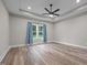 A bedroom featuring light colored walls, wood flooring, a modern ceiling fan and window with curtains at 1850 Willie Pace Rd, Burlington, NC 27217