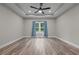 A bedroom featuring light colored walls, wood flooring, a modern ceiling fan and window with curtains at 1850 Willie Pace Rd, Burlington, NC 27217