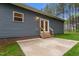 Home exterior showing gray siding, outdoor lighting, French door access, and a concrete patio at 1850 Willie Pace Rd, Burlington, NC 27217