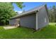 Exterior view of a home showcasing gray siding, a well-maintained lawn, and a back patio at 1850 Willie Pace Rd, Burlington, NC 27217