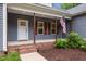 Inviting front porch with brick steps, American flag, and wooden pillars, creating a warm welcome at 1850 Willie Pace Rd, Burlington, NC 27217