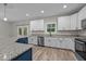 A kitchen with white cabinets, stainless steel appliances, granite countertops and a large island at 1850 Willie Pace Rd, Burlington, NC 27217