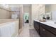 Bathroom featuring double sink vanity, tiled shower and view to bedroom at 204 Mill Chapel Rd, Chapel Hill, NC 27517