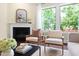 Bright living room features fireplace, modern furnishings, hardwood floors, and large windows with lush backyard views at 204 Mill Chapel Rd, Chapel Hill, NC 27517