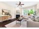 Bright living room features hardwood floors, neutral walls, fireplace, modern furnishings, and large windows with backyard views at 204 Mill Chapel Rd, Chapel Hill, NC 27517