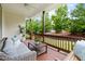 Inviting covered porch with comfortable seating, a coffee table, and views of the landscaped yard at 204 Mill Chapel Rd, Chapel Hill, NC 27517