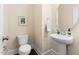 Powder room featuring pedestal sink, round mirror, and ceramic toilet at 204 Mill Chapel Rd, Chapel Hill, NC 27517