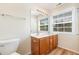 Bathroom featuring double sinks, wood cabinets, and a large mirror with modern lighting at 2111 Piney Brook Rd # 101, Raleigh, NC 27614