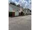 Row of garages with brick facade accents, white siding, and grey roofing at 2111 Piney Brook Rd # 101, Raleigh, NC 27614