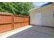 Private patio area with a stained wood fence, convenient access door, and concrete surface at 2111 Piney Brook Rd # 101, Raleigh, NC 27614