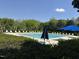 Community swimming pool with chairs and umbrellas, surrounded by green trees at 2111 Piney Brook Rd # 101, Raleigh, NC 27614