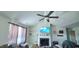 This living room features a vaulted ceiling, a fan, a fireplace, and lots of natural light at 212 Placid Pond Dr, Broadway, NC 27505