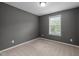 This bedroom features neutral colored walls, carpet flooring, a window and baseboard molding at 2316 Apex Peakway, Apex, NC 27502