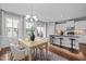 Open-concept dining room next to the kitchen with chandelier and view to the deck at 2316 Apex Peakway, Apex, NC 27502