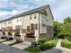 Townhome showcases exterior elevation, garage, complemented by green lawn and lush shrubbery at 2316 Apex Peakway, Apex, NC 27502