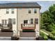 Exterior rear view showcases townhome garages, balconies, complemented by green lawn and trees at 2316 Apex Peakway, Apex, NC 27502