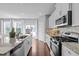 Modern kitchen features stainless appliances, granite counters, and a view to the outside deck at 2316 Apex Peakway, Apex, NC 27502