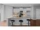 Bright kitchen with granite island with bar stool seating and stainless steel appliances at 2316 Apex Peakway, Apex, NC 27502