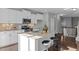 Kitchen with island seating, granite counters, white cabinets and stainless appliances at 2316 Apex Peakway, Apex, NC 27502