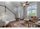 Open-concept living room featuring staircase, hardwood floors, and abundant natural light at 2316 Apex Peakway, Apex, NC 27502