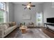 Spacious living room with hardwood floors, ceiling fan, modern decor, and natural light at 2316 Apex Peakway, Apex, NC 27502