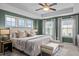 This primary bedroom boasts a tray ceiling, a ceiling fan, and three windows offering ample natural light at 2316 Apex Peakway, Apex, NC 27502