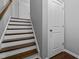 Interior staircase featuring hardwood steps with white risers, leading to the upper level at 2316 Apex Peakway, Apex, NC 27502