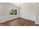 Traditional dining room with wood floors, wainscoting, and a large window with natural light at 233 Theys Mill Way, Fuquay Varina, NC 27526