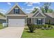 Charming home with a two-car garage, manicured lawn, and neutral gray siding under a sunny blue sky at 233 Theys Mill Way, Fuquay Varina, NC 27526