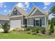Charming home featuring a two-car garage, manicured lawn, and neutral siding at 233 Theys Mill Way, Fuquay Varina, NC 27526