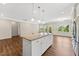 Kitchen island with granite counters and stainless steel appliances overlooking the living room in an open concept floor plan at 233 Theys Mill Way, Fuquay Varina, NC 27526