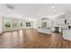 Bright, open floor plan with wood flooring featuring an island kitchen with granite countertops and stainless appliances at 233 Theys Mill Way, Fuquay Varina, NC 27526