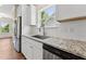 Modern kitchen with granite countertops, stainless steel appliances, and a subway tile backsplash under a window at 233 Theys Mill Way, Fuquay Varina, NC 27526