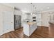 Kitchen with white cabinets and granite countertops, featuring a kitchen island and stainless-steel appliances at 233 Theys Mill Way, Fuquay Varina, NC 27526