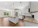 Open floor plan of kitchen featuring stainless steel appliances, granite countertops, island and white shaker cabinets at 233 Theys Mill Way, Fuquay Varina, NC 27526