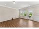 Bright living room featuring wood-look floors, white trim, and a back door at 233 Theys Mill Way, Fuquay Varina, NC 27526