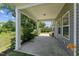 Covered patio with concrete flooring, white support columns, and view of landscaped yard at 233 Theys Mill Way, Fuquay Varina, NC 27526