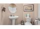 The bathroom features a sleek pedestal sink, round mirror, and modern fixtures at 239 Moyer Dr, Graham, NC 27253