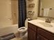 Bathroom featuring a shower-tub combo, modern vanity, and convenient storage shelves at 243 Nortwick Rd, Rolesville, NC 27571