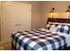 Bedroom showcasing a cozy bed with a black-and-white checkered comforter and stylish wall sconces at 243 Nortwick Rd, Rolesville, NC 27571