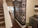 Unique entryway with motivational wall art, open staircase, and access to laundry at 243 Nortwick Rd, Rolesville, NC 27571