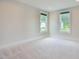 Inviting bedroom featuring soft carpeting, fresh paint, and two bright windows at 2737 Willow Rock Ln, Apex, NC 27523