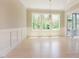 Bright dining room featuring wainscoting, large windows, chandelier and access to porch at 2737 Willow Rock Ln, Apex, NC 27523
